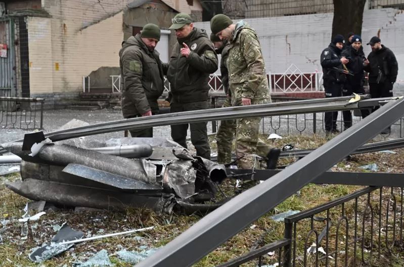 In Kyiv, police and security personnel inspect the remnants of a shell that fell in the street.
